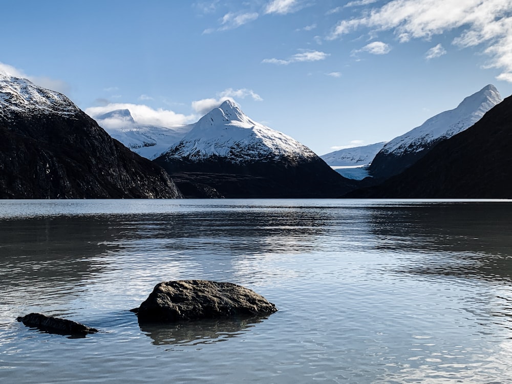 body of water near mountain under blue sky during daytime