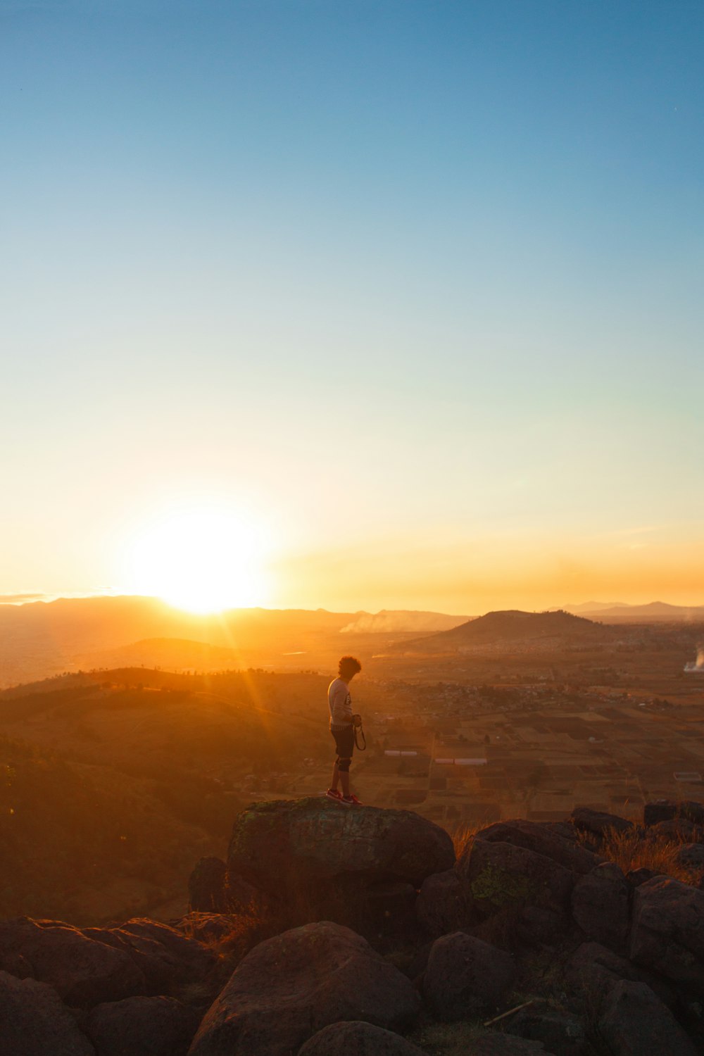 homme debout sur la formation rocheuse au coucher du soleil