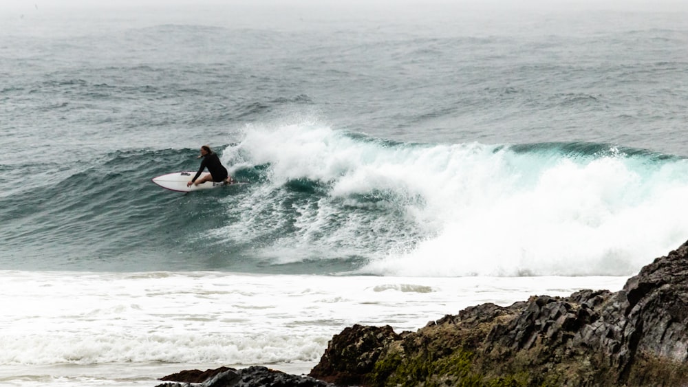 man surfing on sea waves during daytime