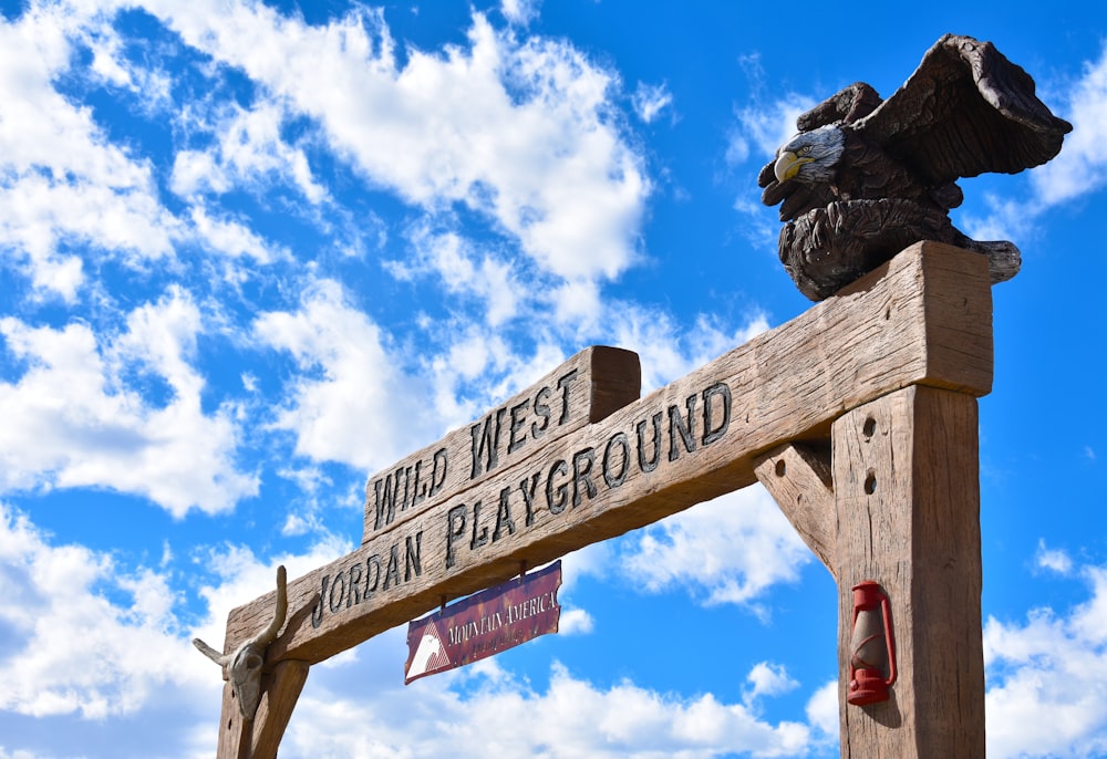 brown wooden signage under blue sky during daytime