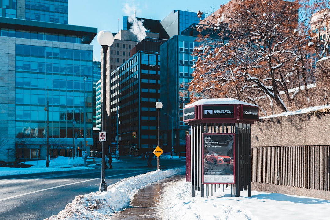 red telephone booth on snow covered ground near brown concrete building during daytime