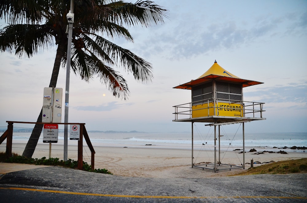 brown wooden lifeguard house on beach during daytime