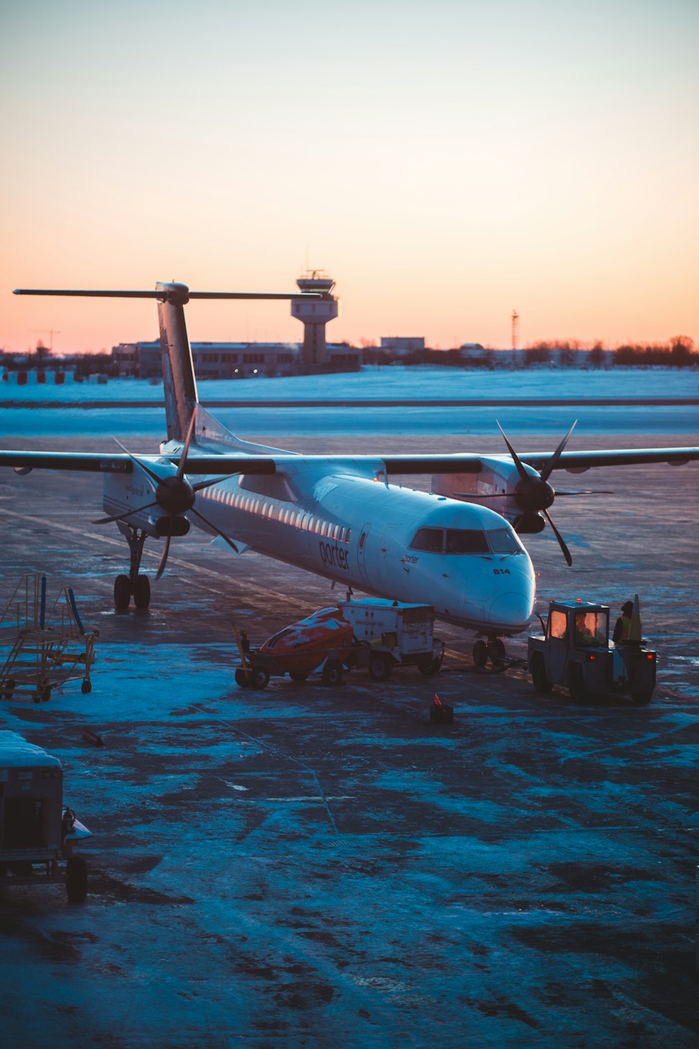 white and blue airplane on dock during daytime