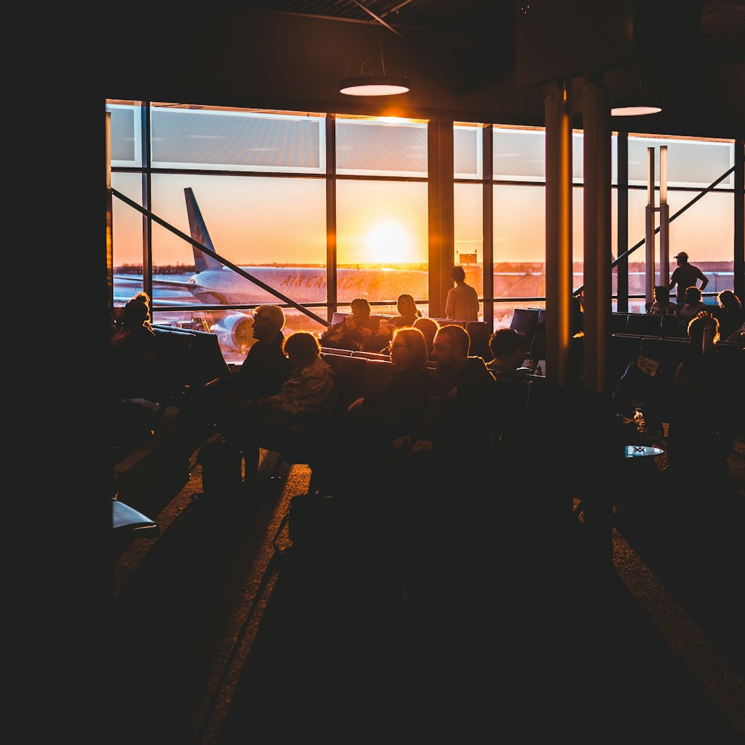 silhouette of people sitting on chair near window during sunset