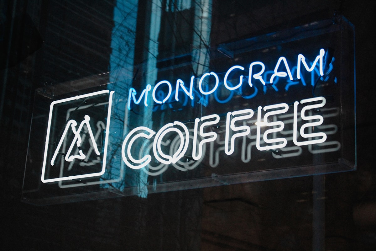 Two people in quiet conversation at a dimly lit table, captured in a candid editorial moment