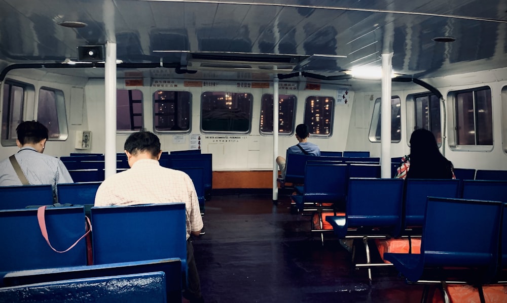 man in white and black checkered dress shirt sitting on blue chair