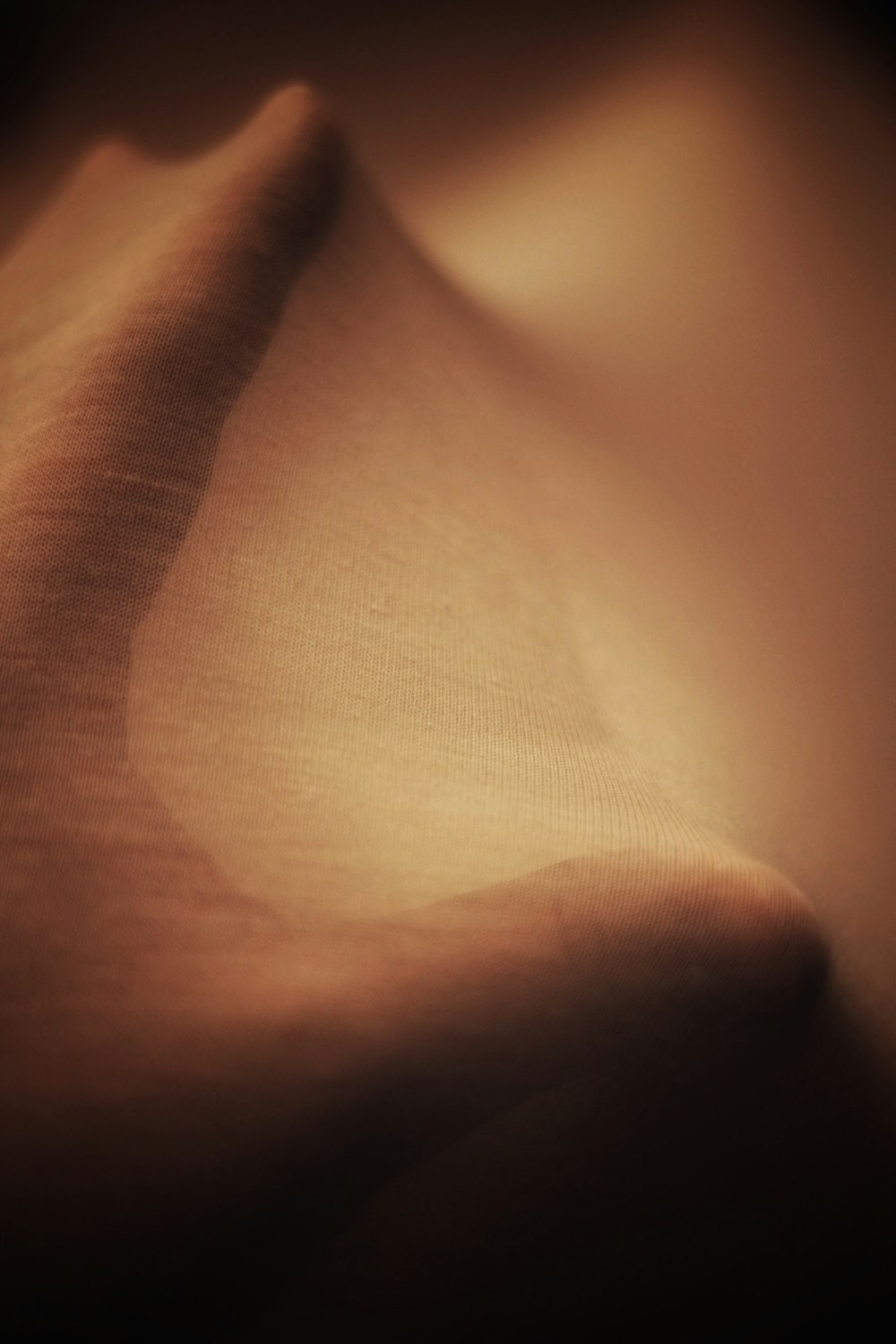 persons hand on brown textile