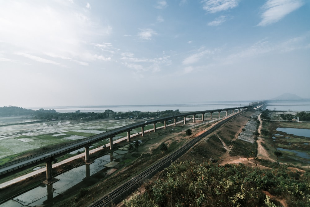 brown wooden bridge over the sea under white clouds during daytime