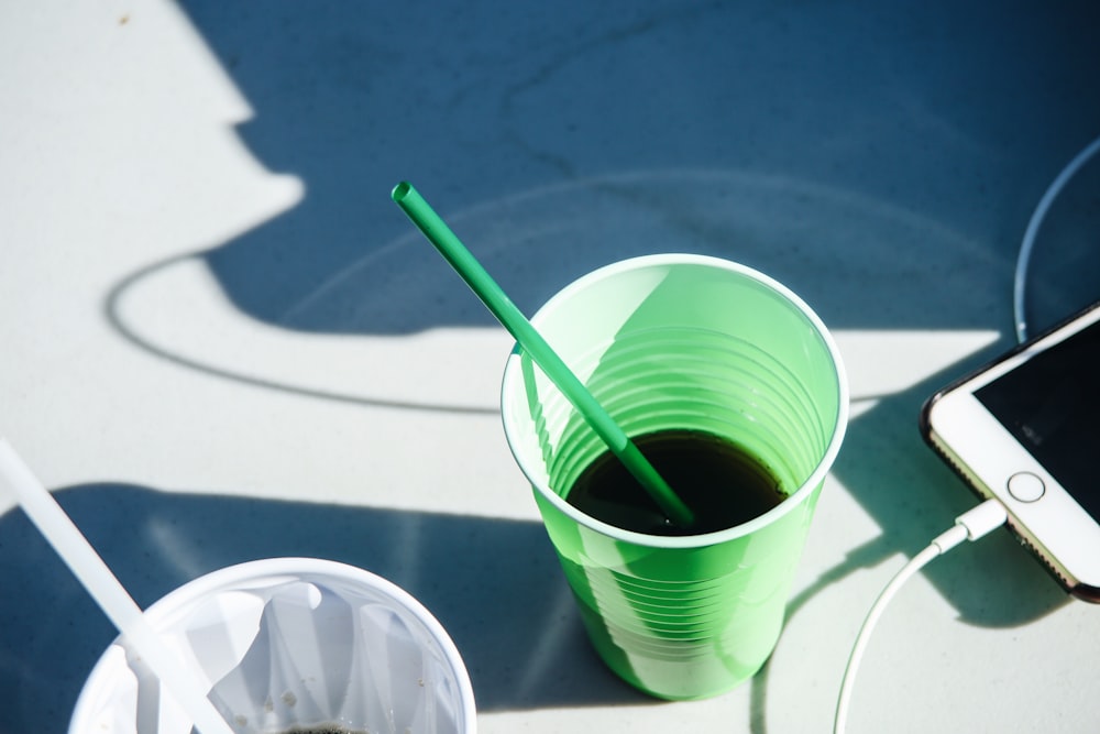 緑のストローと緑と白のプラスチックカップ