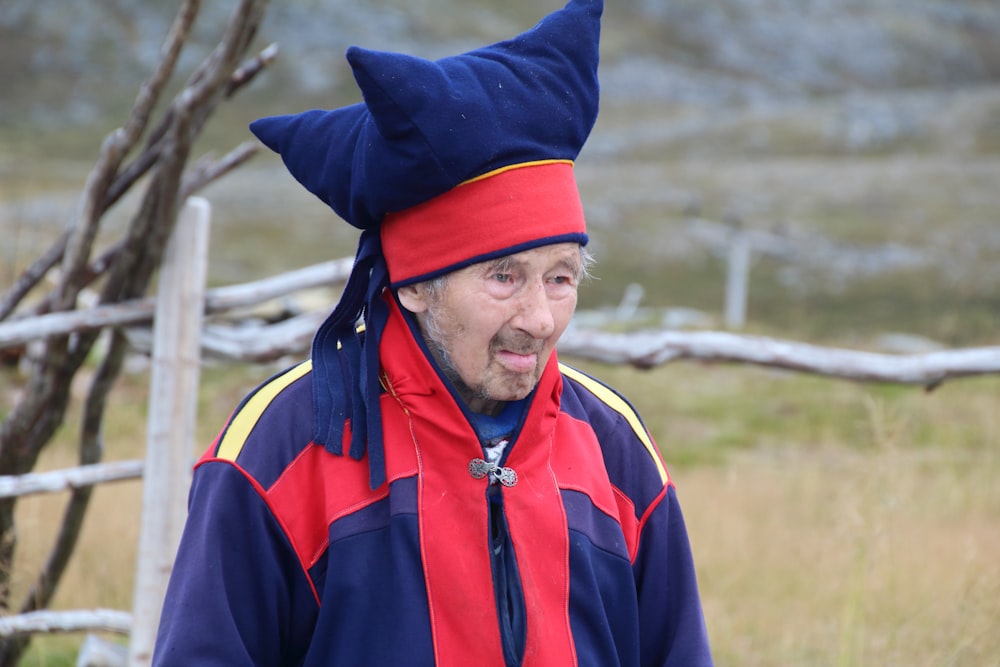 an old man wearing a blue and red hat
