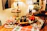 A cozy kitchen scene with warm orange lighting and a festive table set for a holiday meal.