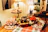 A cozy kitchen scene with warm orange lighting and a festive table set for a holiday meal.
