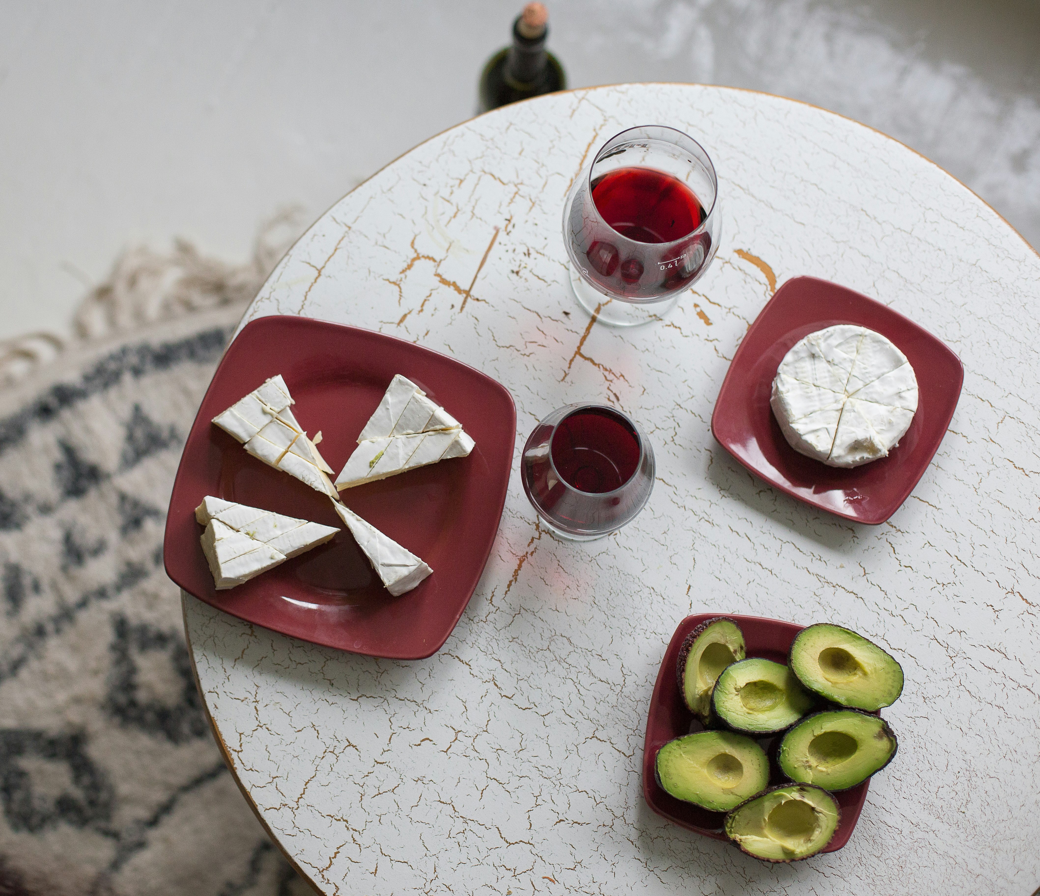 green and red sliced fruits on red and white ceramic plate