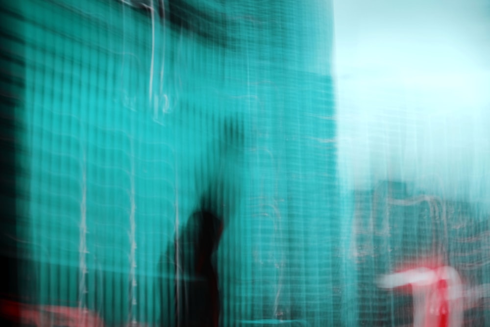 person in blue shirt standing in front of green curtain