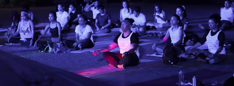 A group of African American men engaging in a meditation session outdoors.