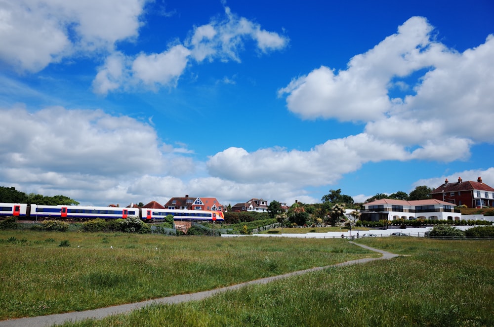 Train rouge et blanc sur rail sous un ciel bleu pendant la journée