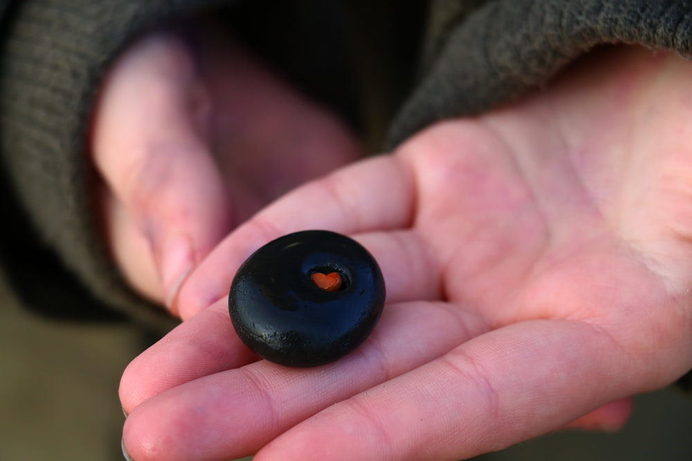 black round ornament on persons hand