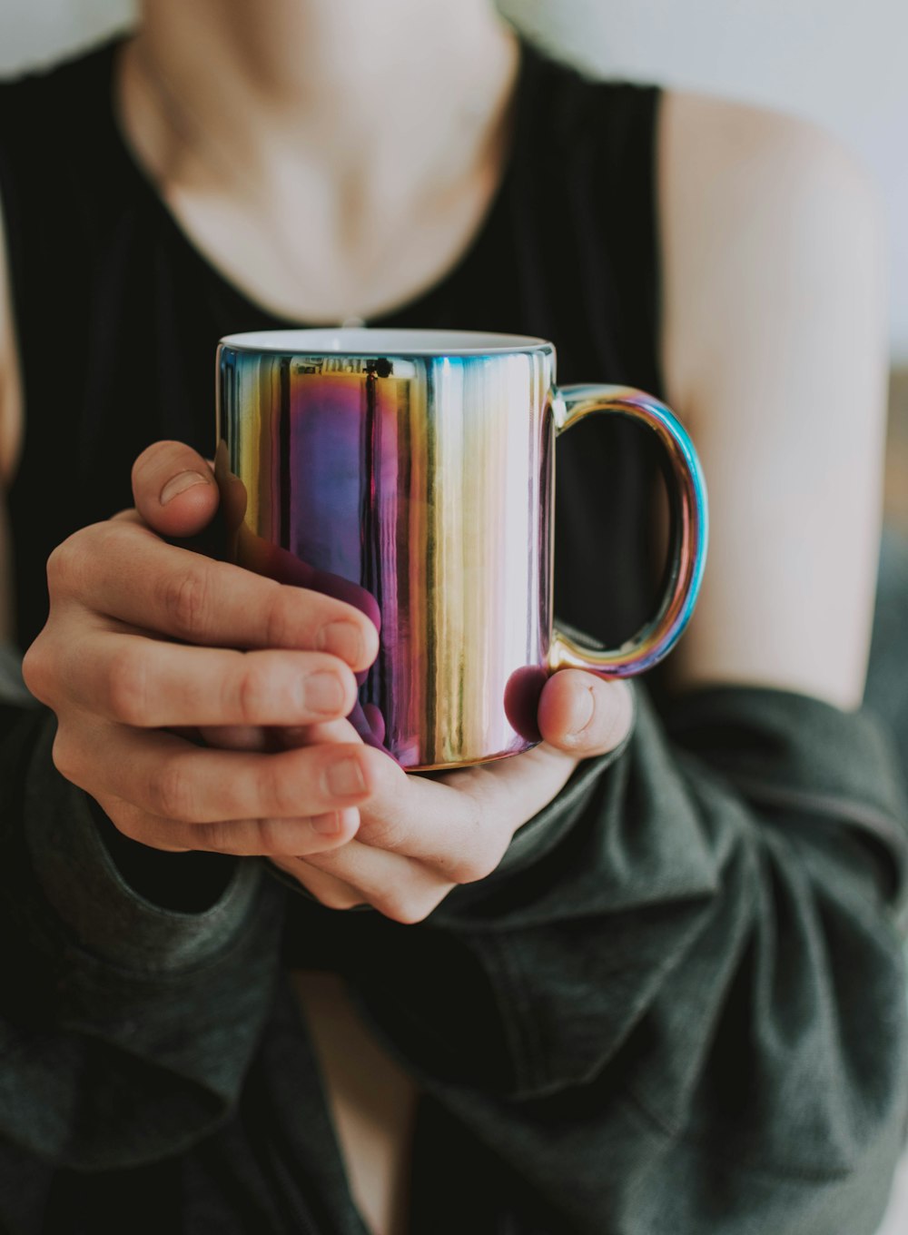 person holding purple and gold ceramic mug