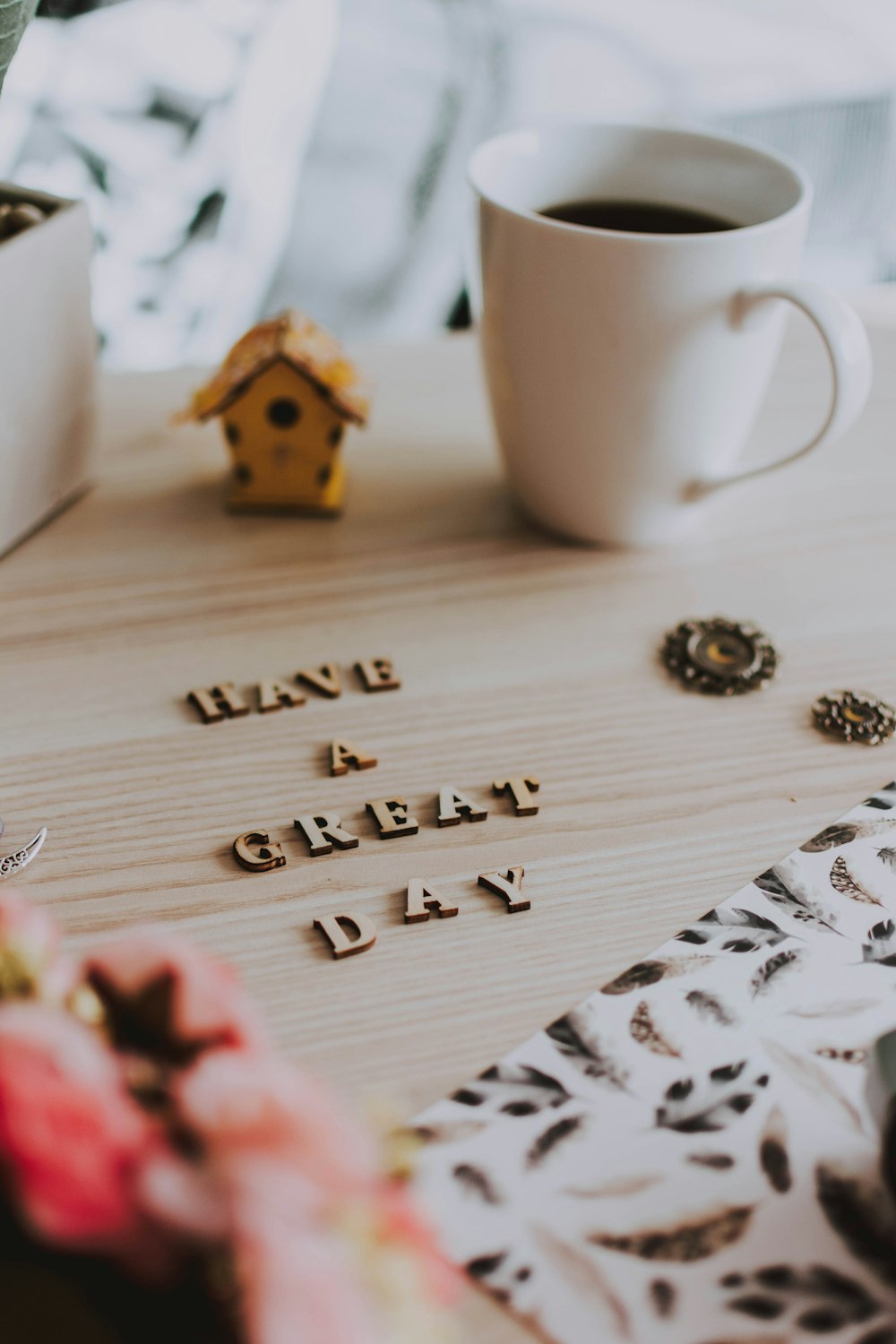 white ceramic mug beside brown wooden house ornament