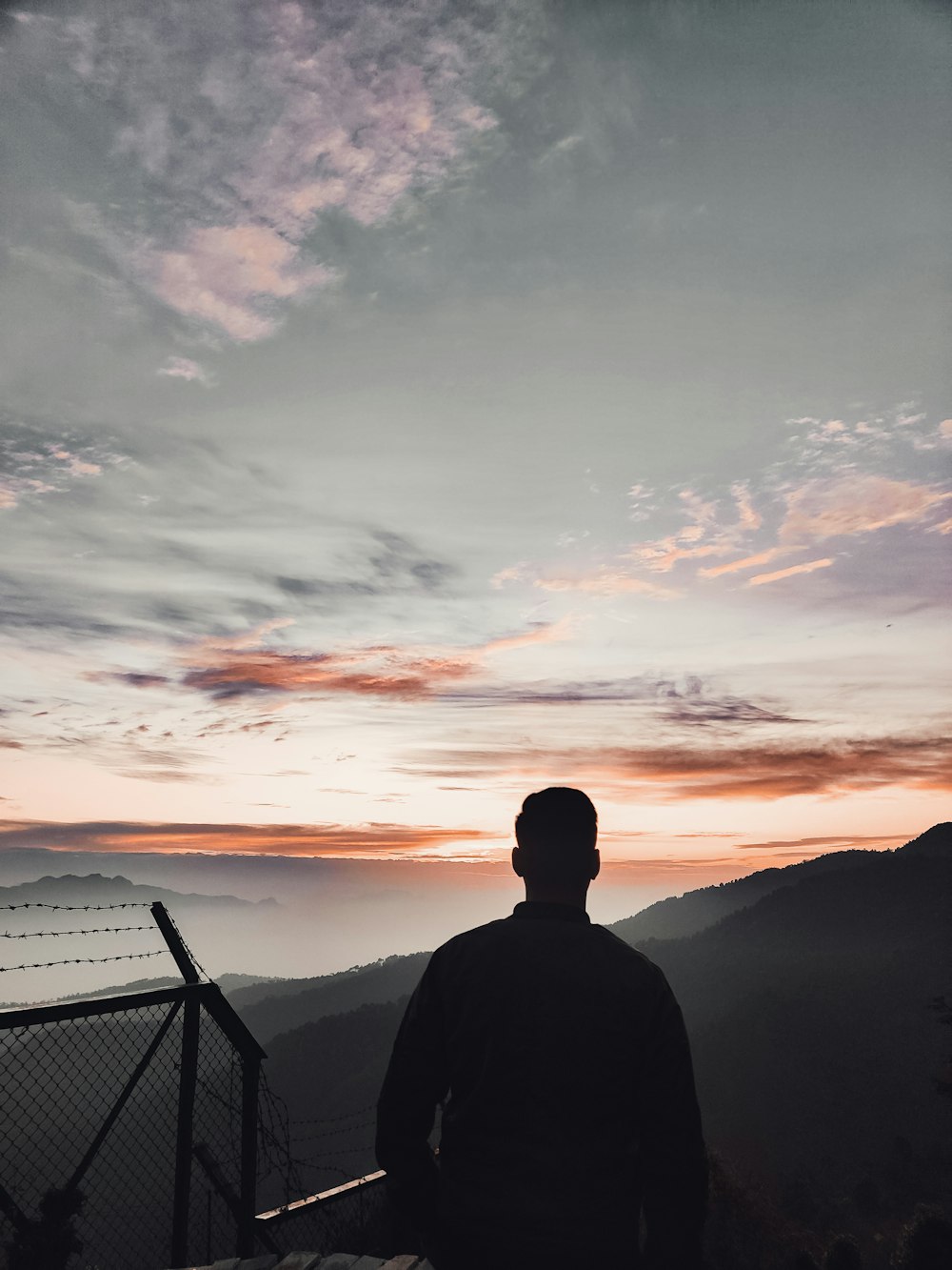 silhouette of man sitting on chair during sunset