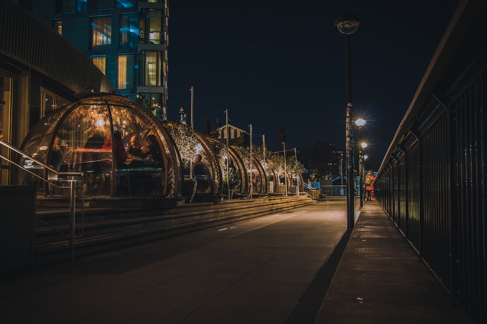 gray concrete road with cars parked on side during night time