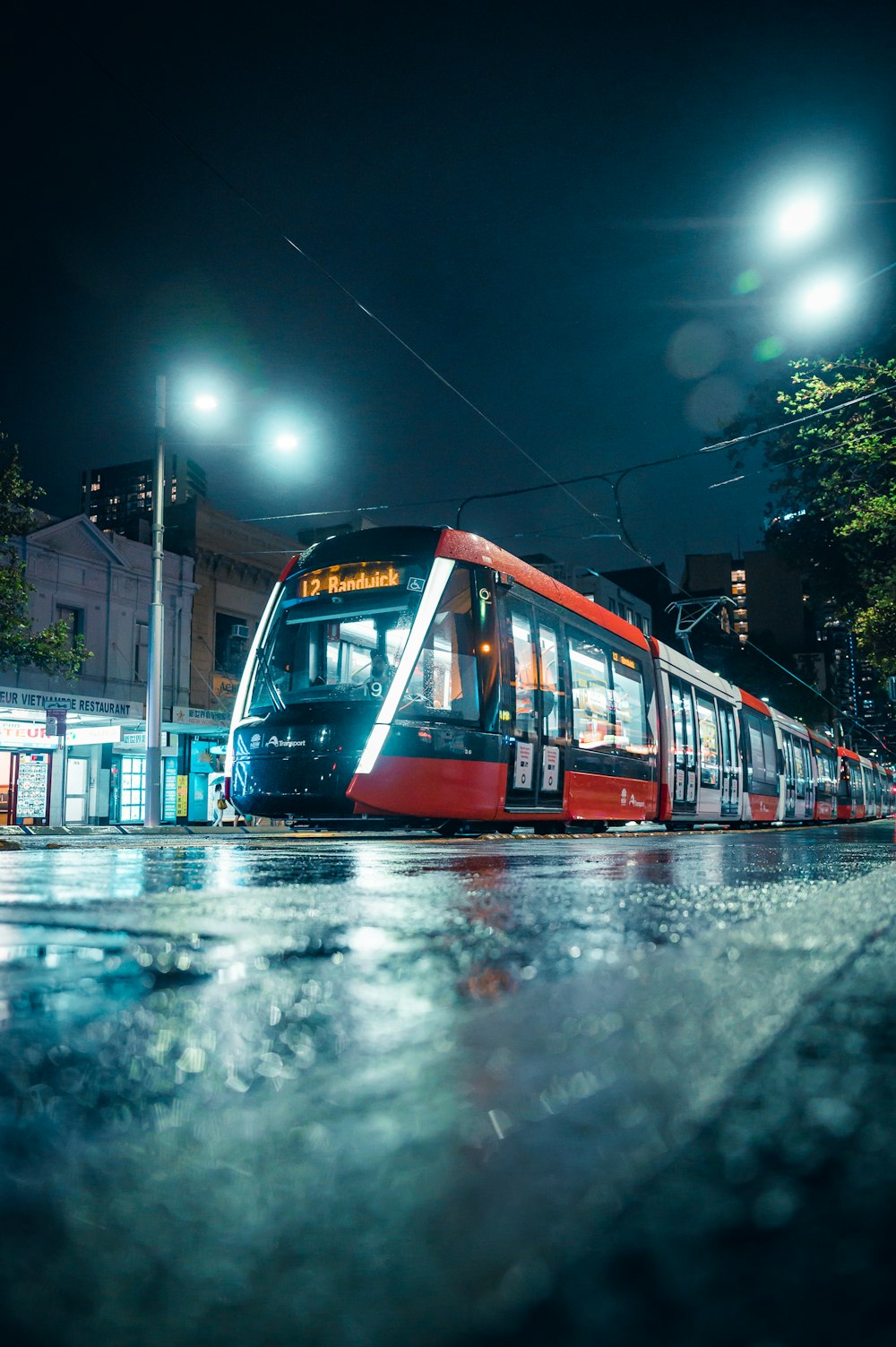 red and white tram on road during night time