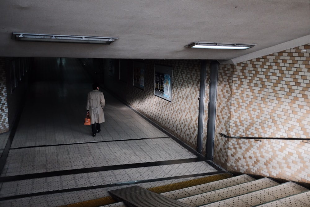 woman in white coat walking on hallway