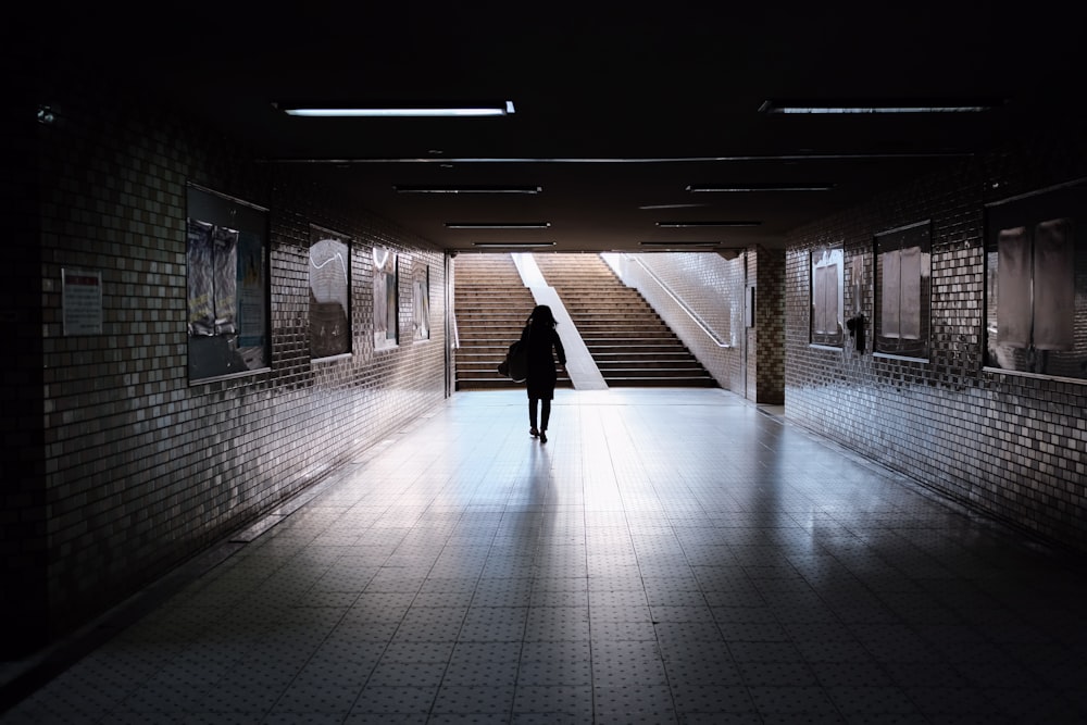 woman in black long sleeve shirt walking on hallway
