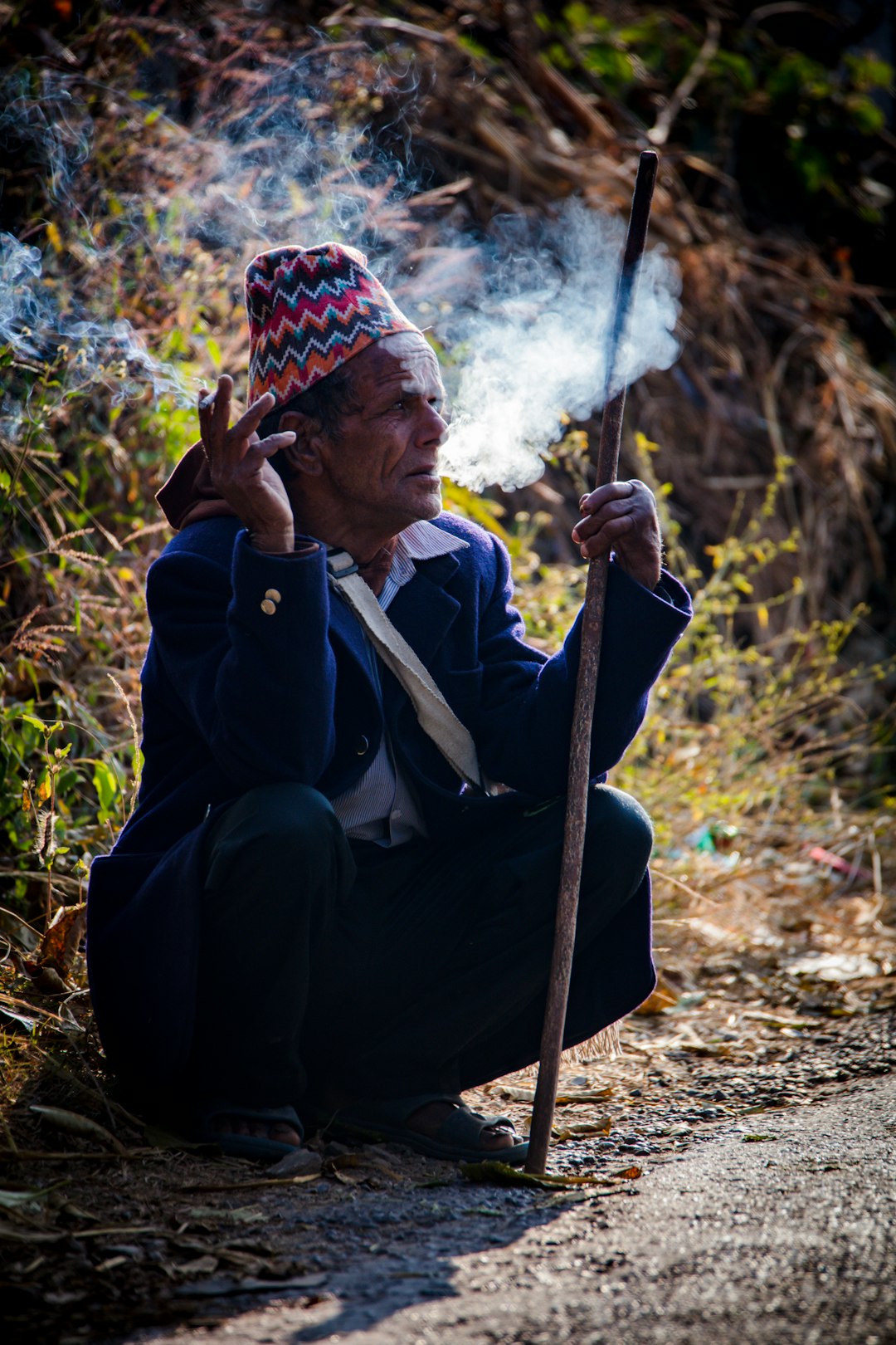 man in black jacket holding stick