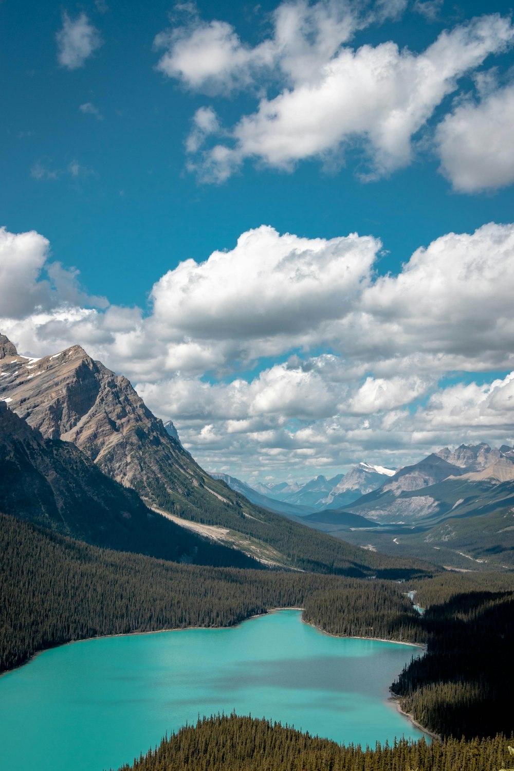 Montagnes vertes et brunes sous un ciel bleu et des nuages blancs pendant la journée