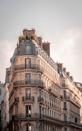 brown and white concrete building under white clouds during daytime