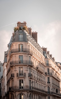 brown and white concrete building under white clouds during daytime