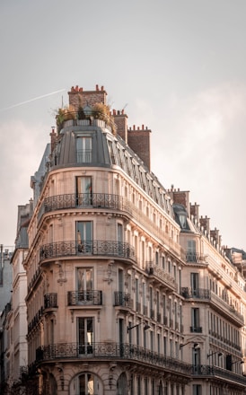 brown and white concrete building under white clouds during daytime