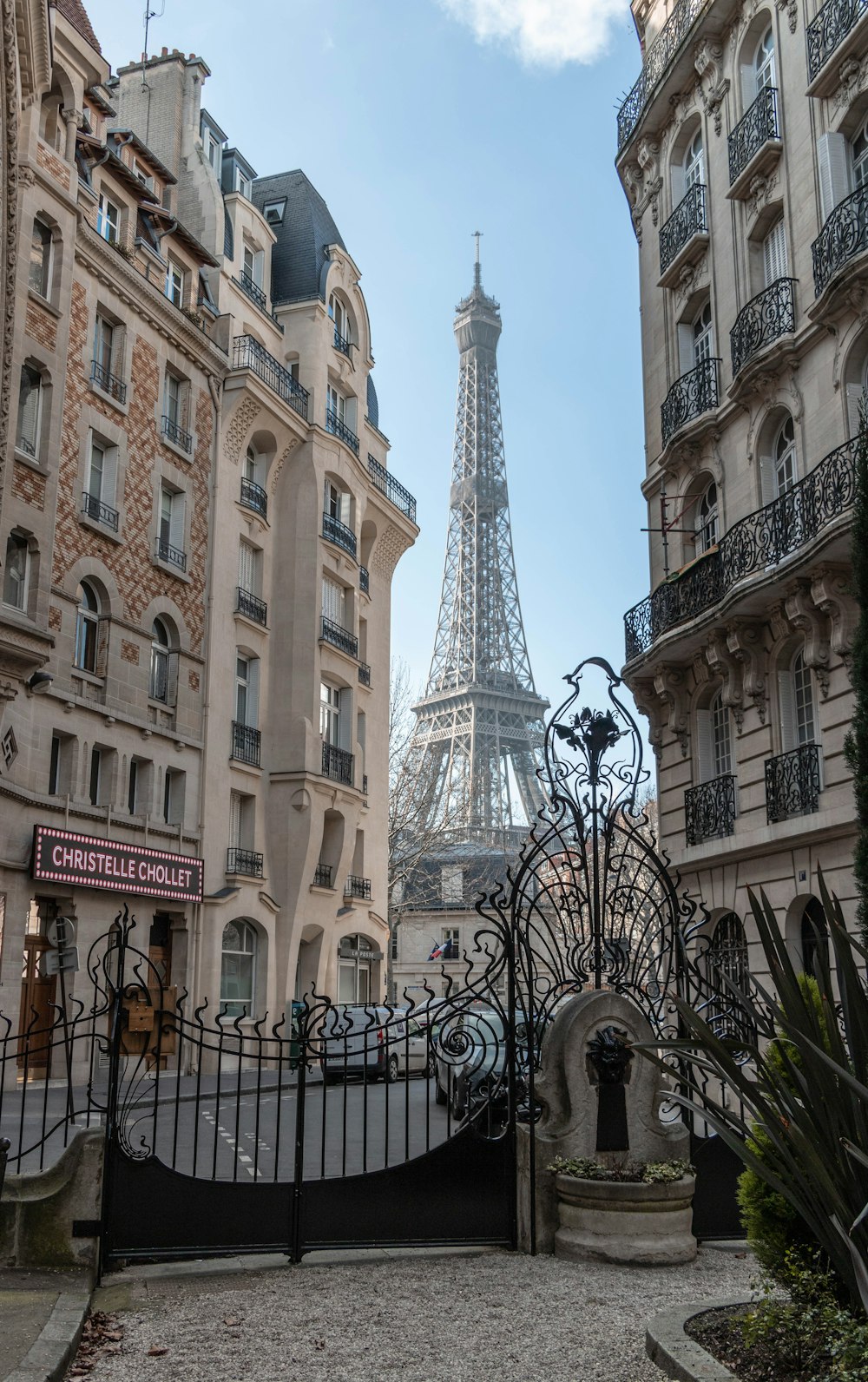 Clôture en métal noir près d’un bâtiment en béton brun pendant la journée