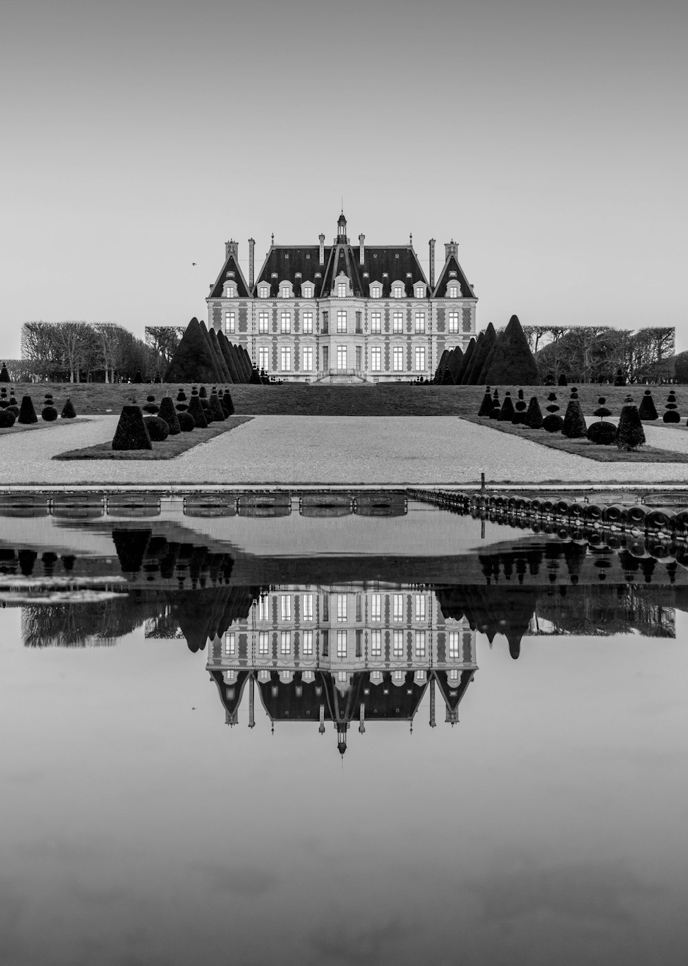 grayscale photo of building near body of water