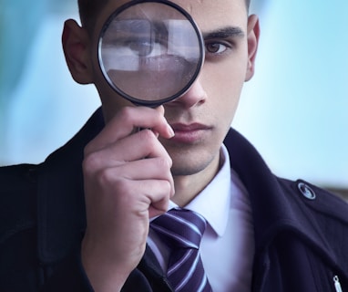 man in black suit holding magnifying glass