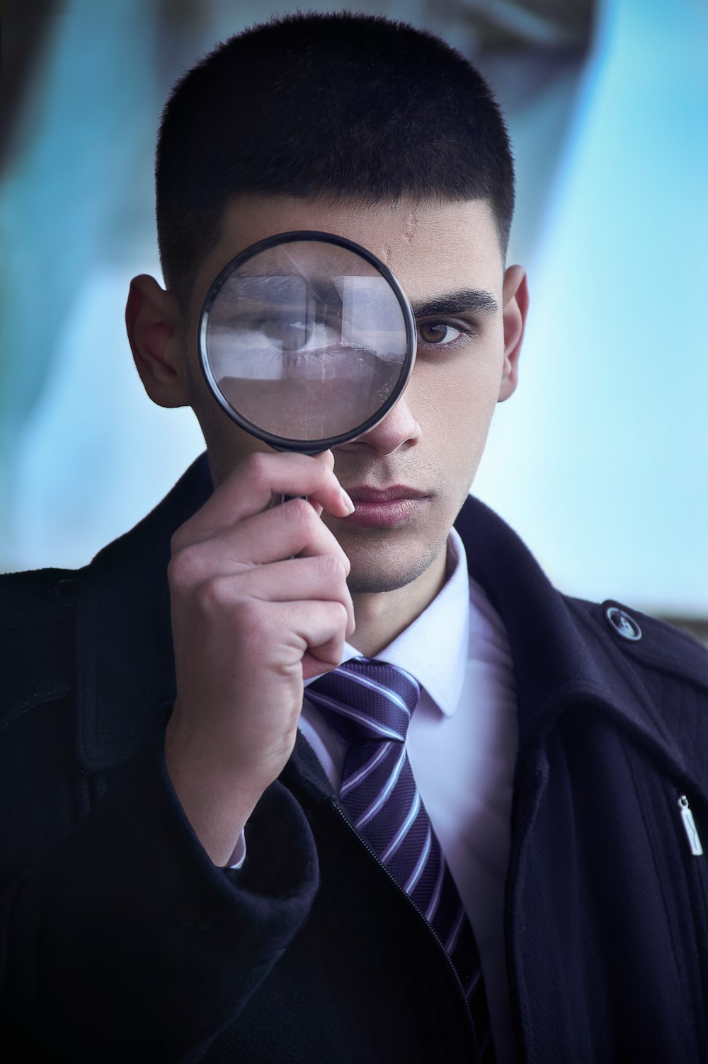 man in black suit holding magnifying glass