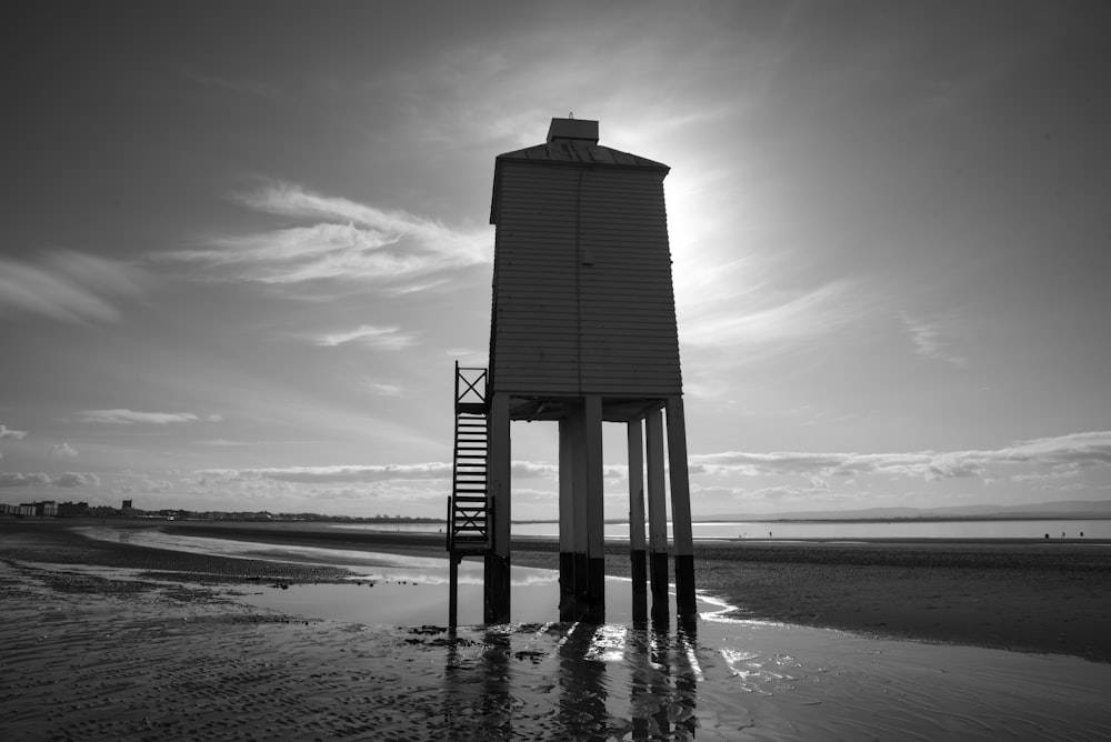 grayscale photo of wooden dock on beach