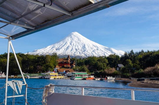 white and brown boat on water near green trees and mountain during daytime in Lago Todos los Santos Chile