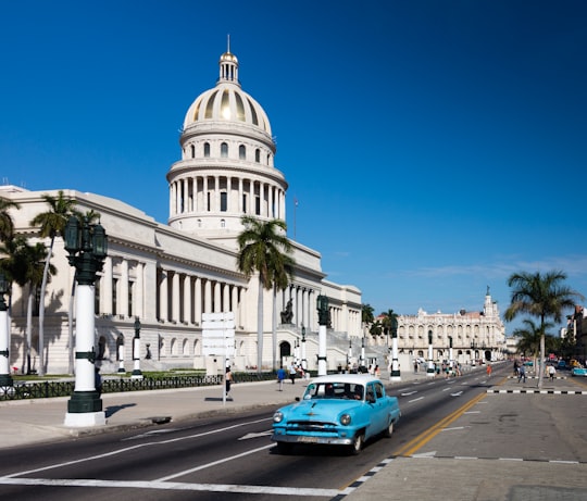 blue car on road near white concrete building during daytime in National Capital Building Cuba
