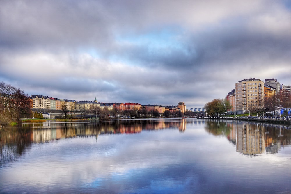 body of water near brown concrete building under gray clouds