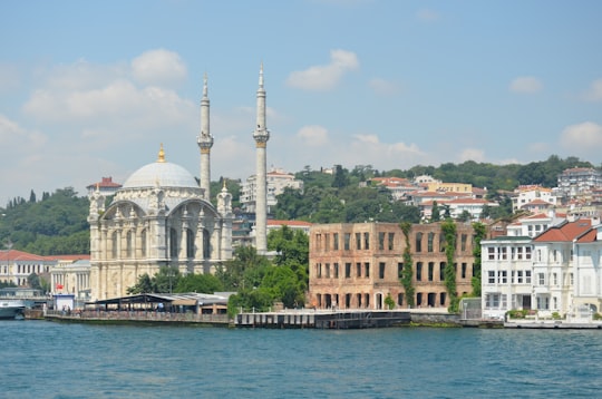 white and brown concrete building near body of water during daytime in Ortaköy Mosque Turkey