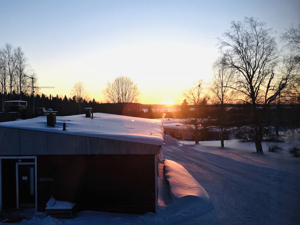 brown wooden house covered with snow during sunset