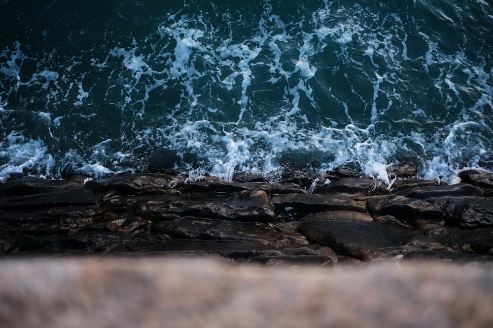 日中に海岸に打ち寄せる海の波がある茶色の岩だらけの海岸