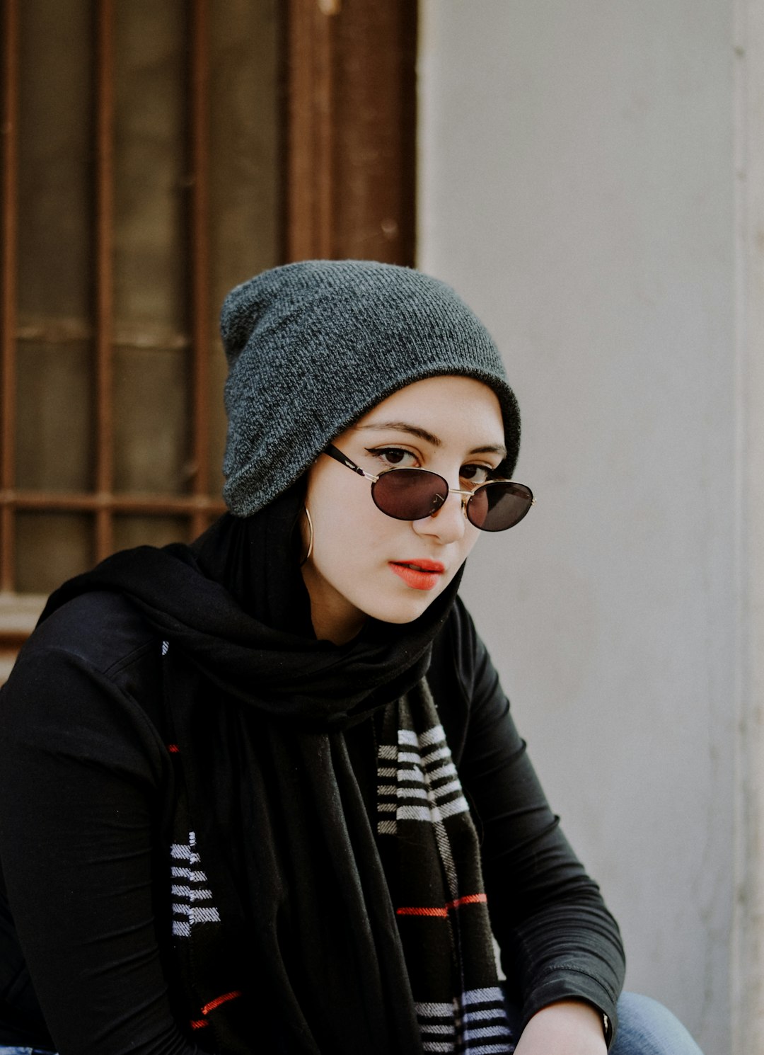 woman in black and gray scarf wearing black framed sunglasses