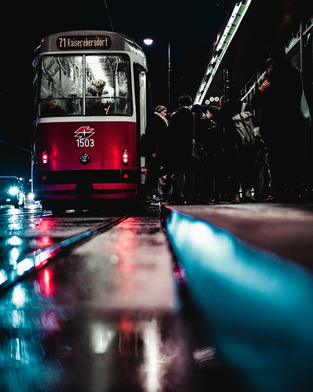 red and black tram on road during night time