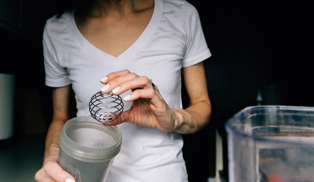 woman in white scoop neck shirt holding white ceramic mug