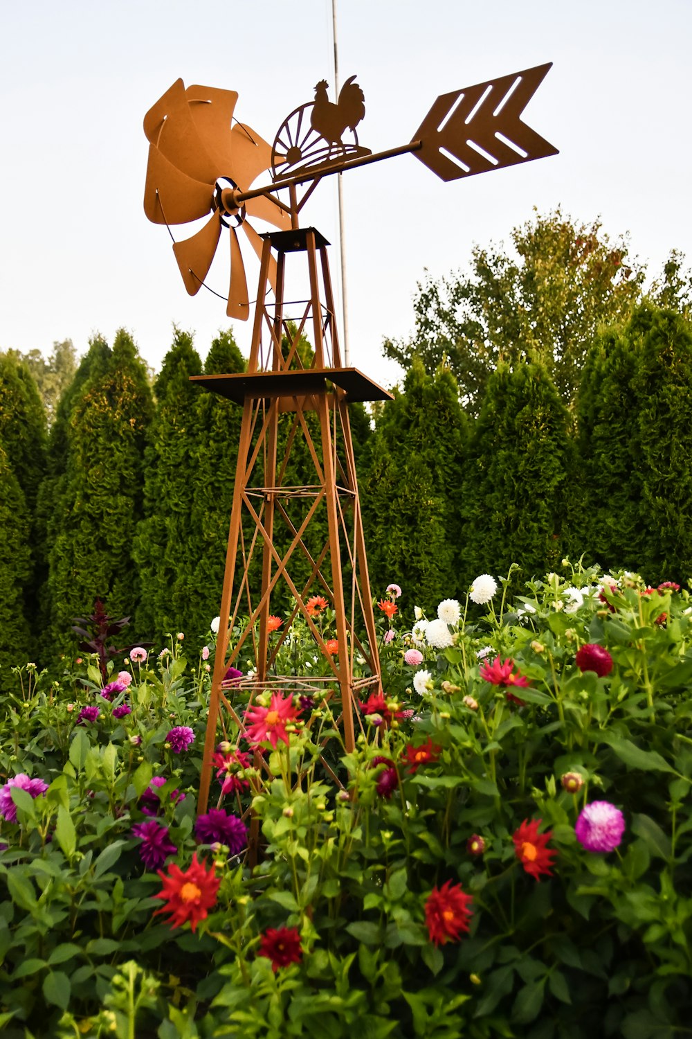 brauner Holzturm mit Blumen und Bäumen