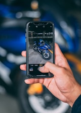 Close-up of a smartphone screen showing a simple motorcycle rental booking app interface.