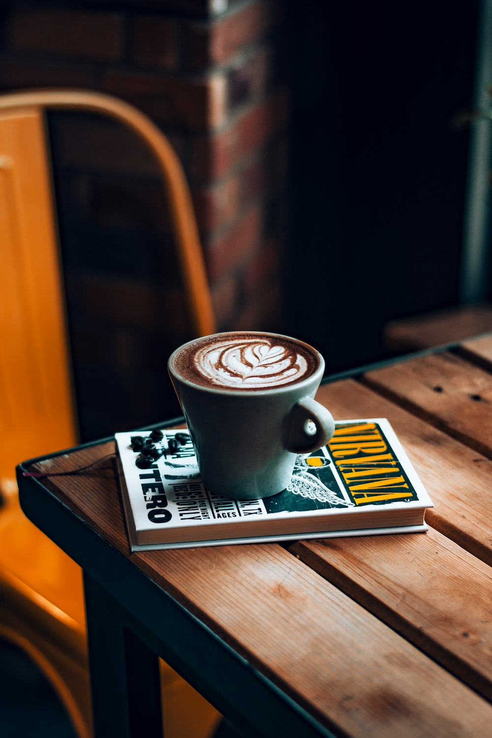 white ceramic mug on white and black book